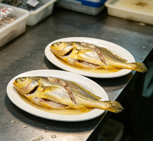Whole fresh fish with golden skin, plated